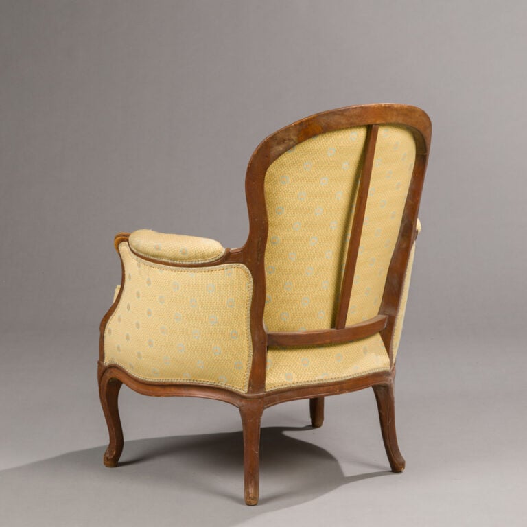 Bergère en bois naturel mouluré garnie de tissu jaune. - Époque Louis XV, parti…