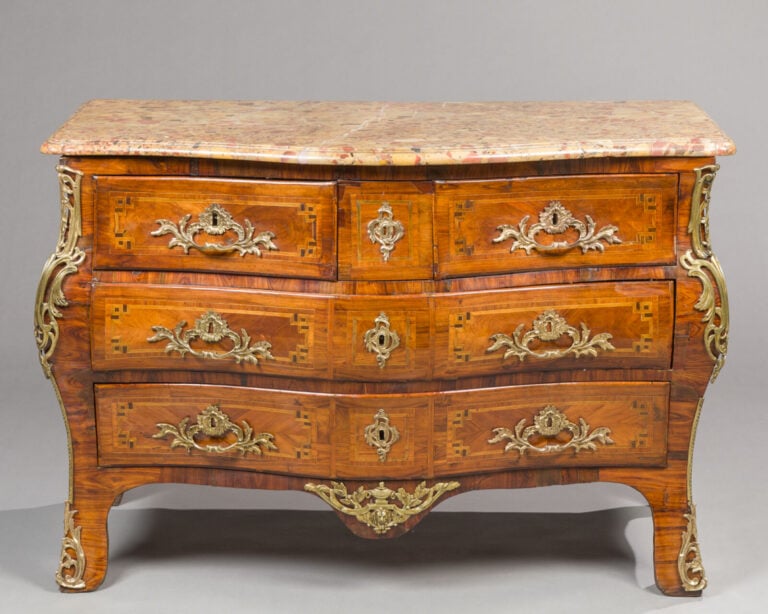 Commode marquetée de bois de rose en quartefeuilles dans des réserves - à filet…
