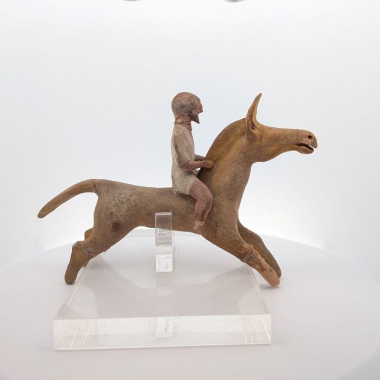 Figurine de cavalier sur un cheval bondissant : il est vêtu d'une tunique court…