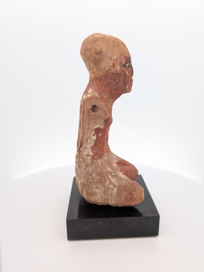 Figurine masculine, les jambes en tailleur, il est vêtu d'un pagne court et d'u…