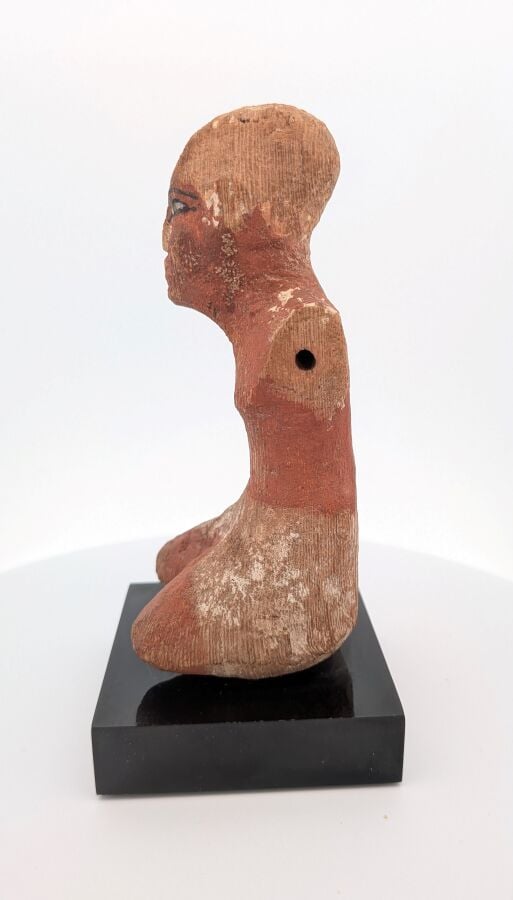 Figurine masculine, les jambes en tailleur, il est vêtu d'un pagne court et d'u…