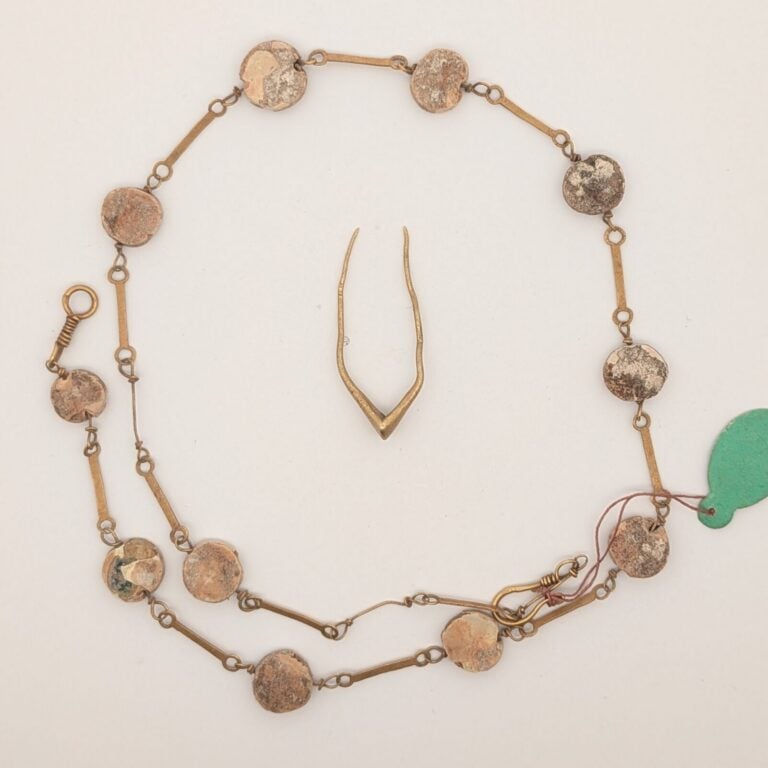 Fin collier composé de tiges d'or et de perles. - Or et terre cuite beige. - Ar…