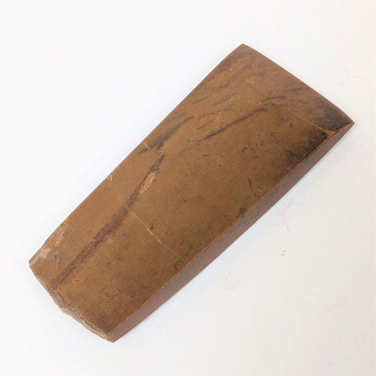 Hache plate à section rectangulaire et tranchant biseauté. - Jaspe brun. - Une…