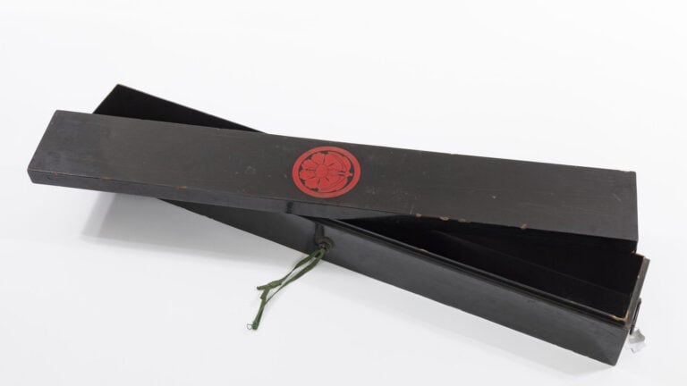 JAPON - XXème siècle - Grande boîte en bois laqué noir pour katanas, à emblème…