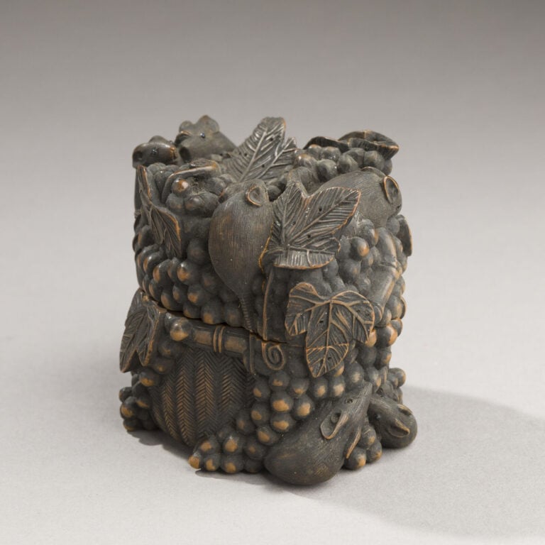 JAPON- XXème siècle - Jolie boîte en bois noirci à décor en relief de 10 petits…