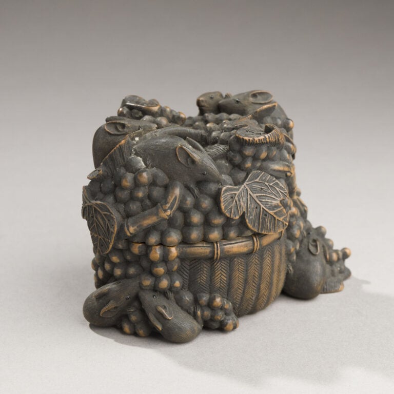JAPON- XXème siècle - Jolie boîte en bois noirci à décor en relief de 10 petits…