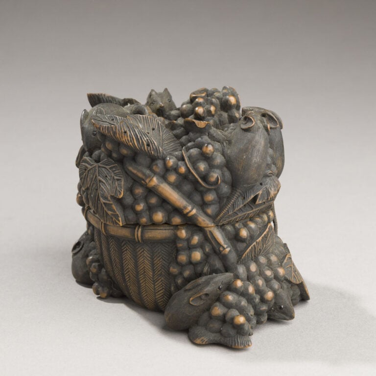 JAPON- XXème siècle - Jolie boîte en bois noirci à décor en relief de 10 petits…