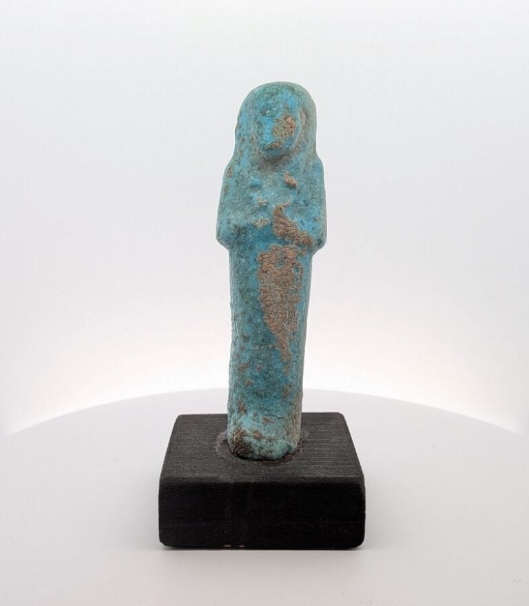 Oushebti anépigraphe portant les instruments aratoires en relief. - Faïence ble…