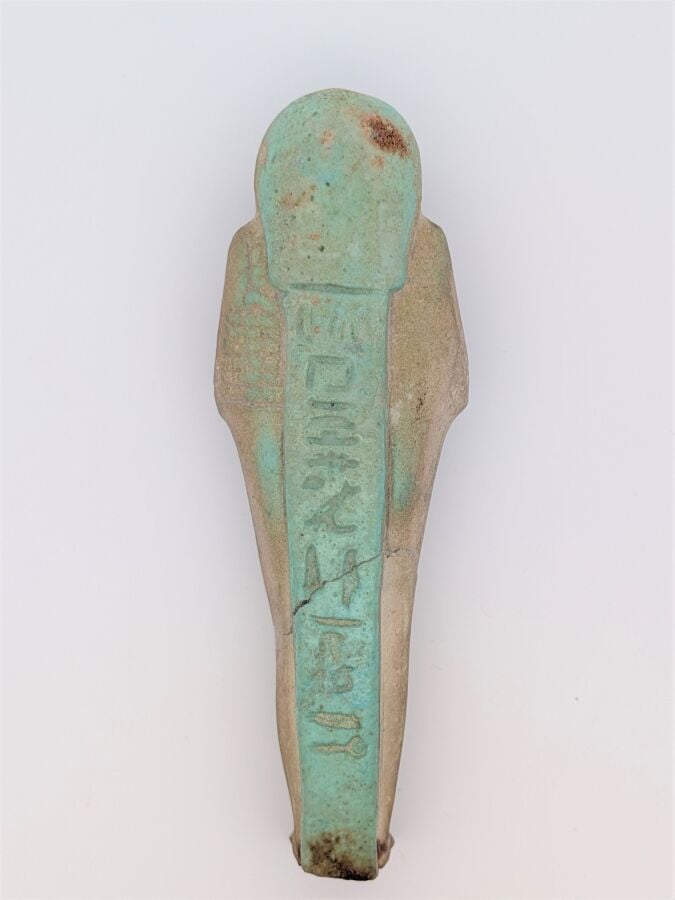 Oushebti portant les instruments aratoires en relief et la barbe postiche. Il e…