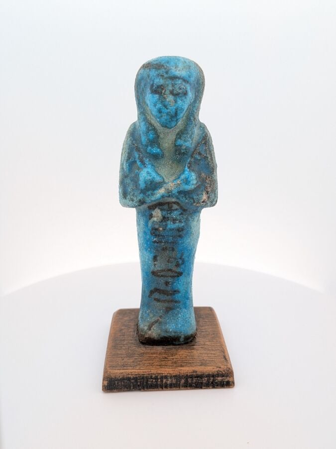 Oushebti portant les instruments oratoires en relief, peint en noir, à la longu…