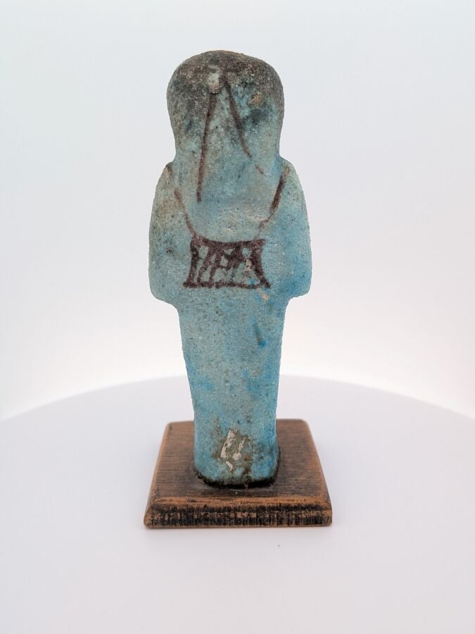 Oushebti portant les instruments oratoires en relief, peint en noir, à la longu…