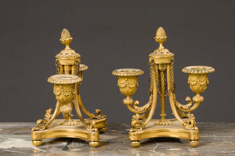 Paire de bougeoirs bas en bronze doré à deux bras de lumières posant - sur une…