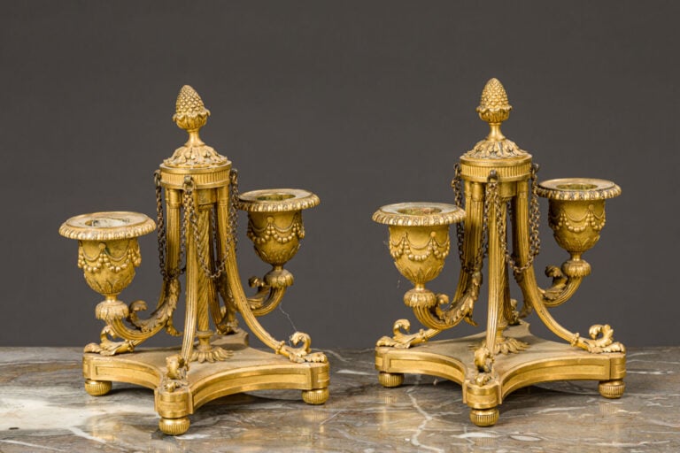 Paire de bougeoirs bas en bronze doré à deux bras de lumières posant - sur une…