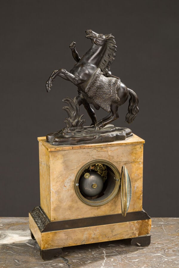 Pendule borne en bronze patiné et - marbre jaune vers 1830 sommé d'un - cheval…
