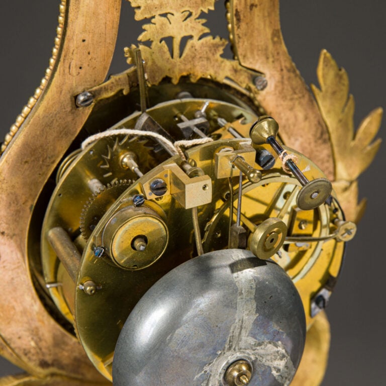 Pendule Lyre en bronze ciselé et doré reposant sur des pieds jarets et sommé d'…