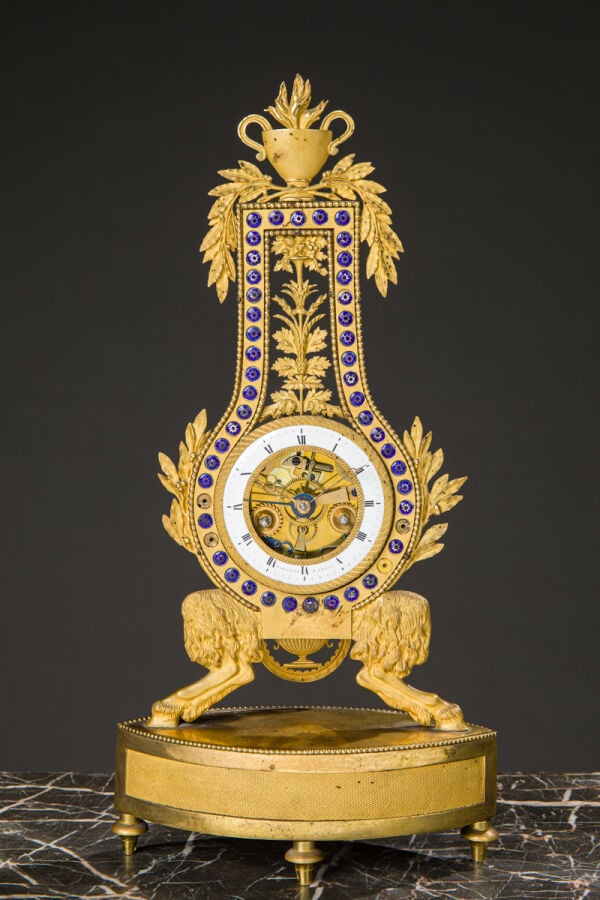 Pendule Lyre en bronze ciselé et doré reposant sur des pieds jarets et sommé d'…