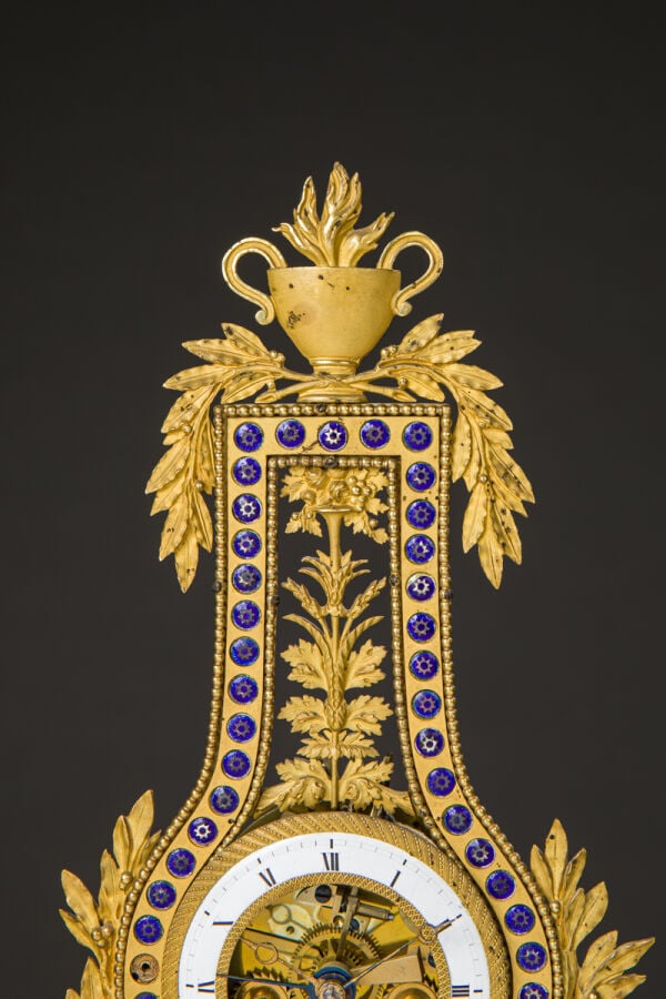 Pendule Lyre en bronze ciselé et doré reposant sur des pieds jarets et sommé d'…