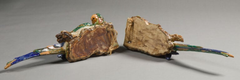Perruche en céramique polychrome et ara sur un tertre en céramique polychrome.…
