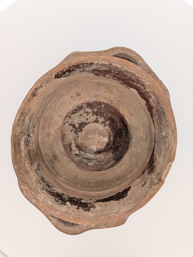 Pyxide tronconique à deux anses en oméga. Elle est décorée d'une frise de moufl…