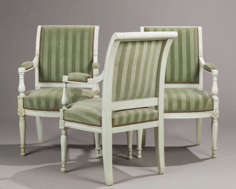 Suite de 3 fauteuils en bois relaqué blanc à - dossiers éversés ; accotoirs à m…