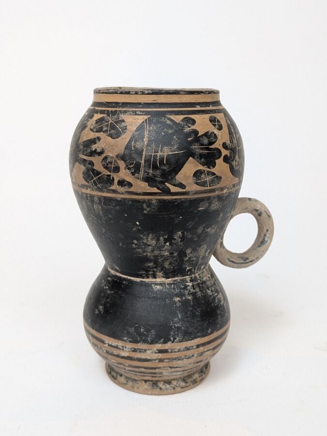 Vase à vernis noir (forme rare) orné d'une frise de poissons passant à gauche d…