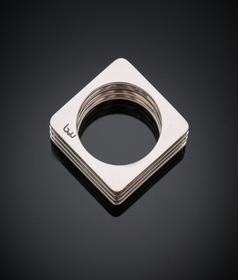 BAGUE "carrée" en or gris (750‰} ajouré, serti de trois diamants taille brillan…