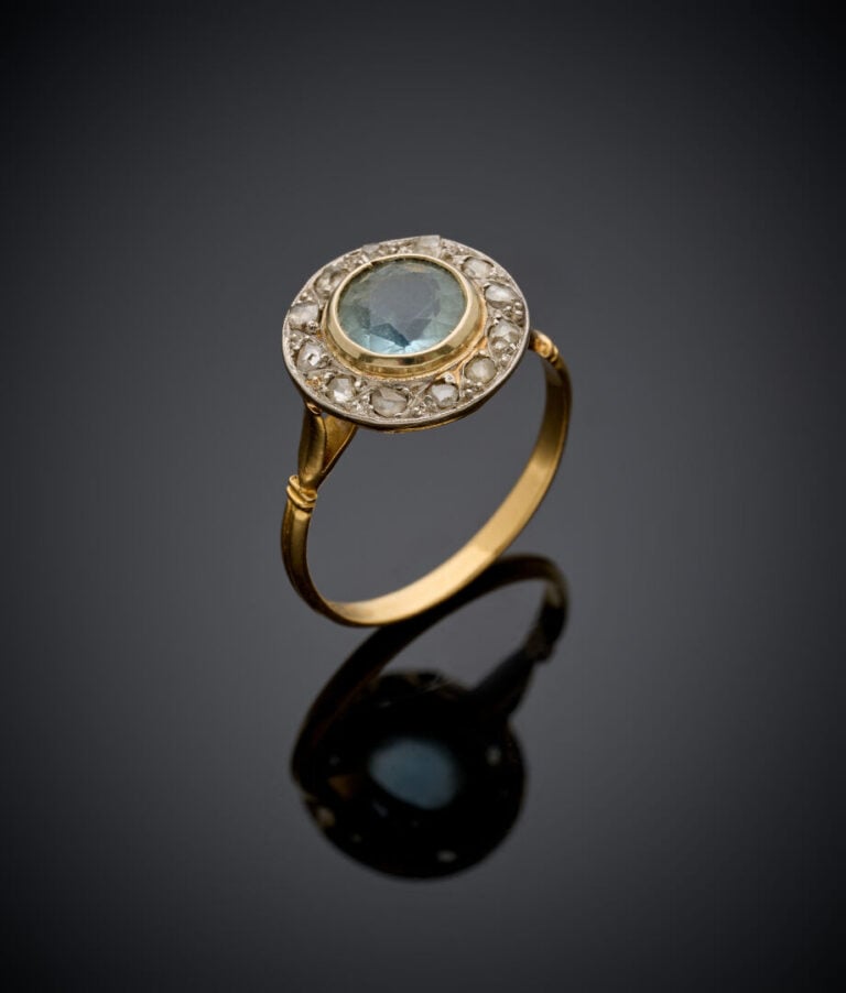 BAGUE circulaire en or jaune (750‰) serti d'une aigue-marine ronde, entourée de…