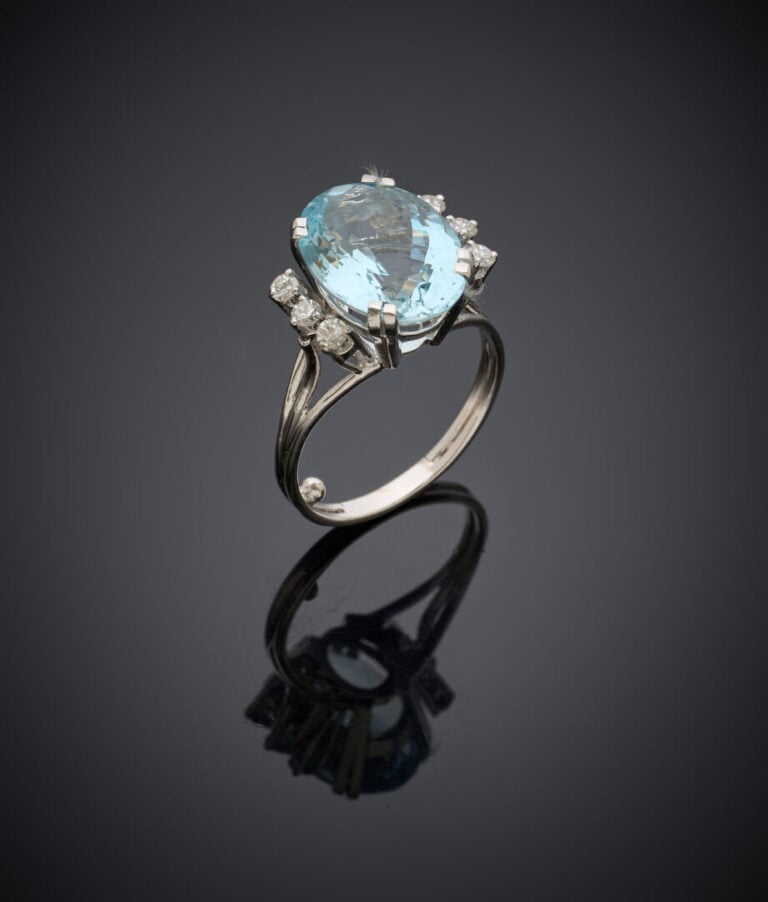 BAGUE en or gris (750‰) serti d'une aigue-marine de forme ovale, épaulée de tro…