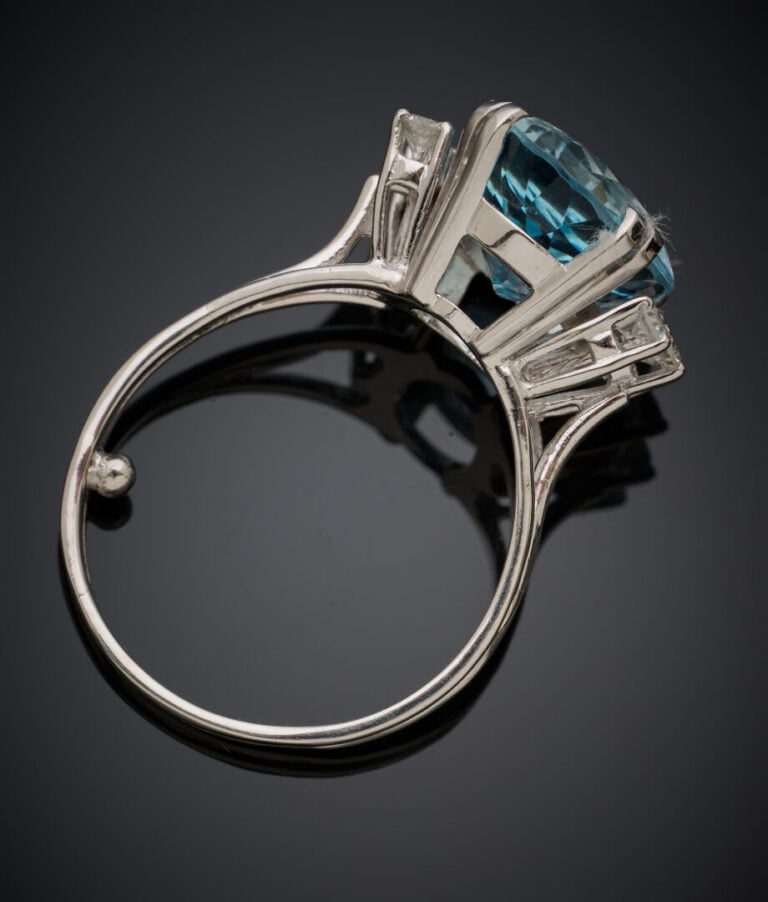 BAGUE en or gris (750‰) serti d'une aigue-marine de forme ovale, épaulée de tro…