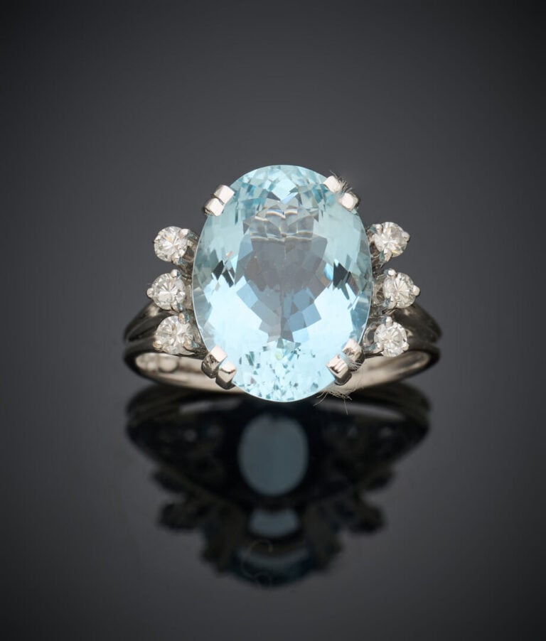 BAGUE en or gris (750‰) serti d'une aigue-marine de forme ovale, épaulée de tro…
