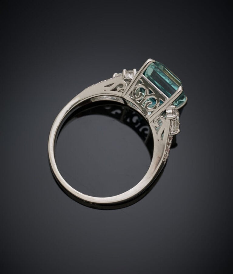 BAGUE en or gris (750‰) serti d'une aigue-marine taillée à degrés, épaulée de d…