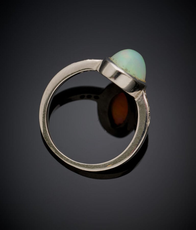 BAGUE en or gris (750‰) serti d'une opale cabochon de forme ovale épaulée de pe…