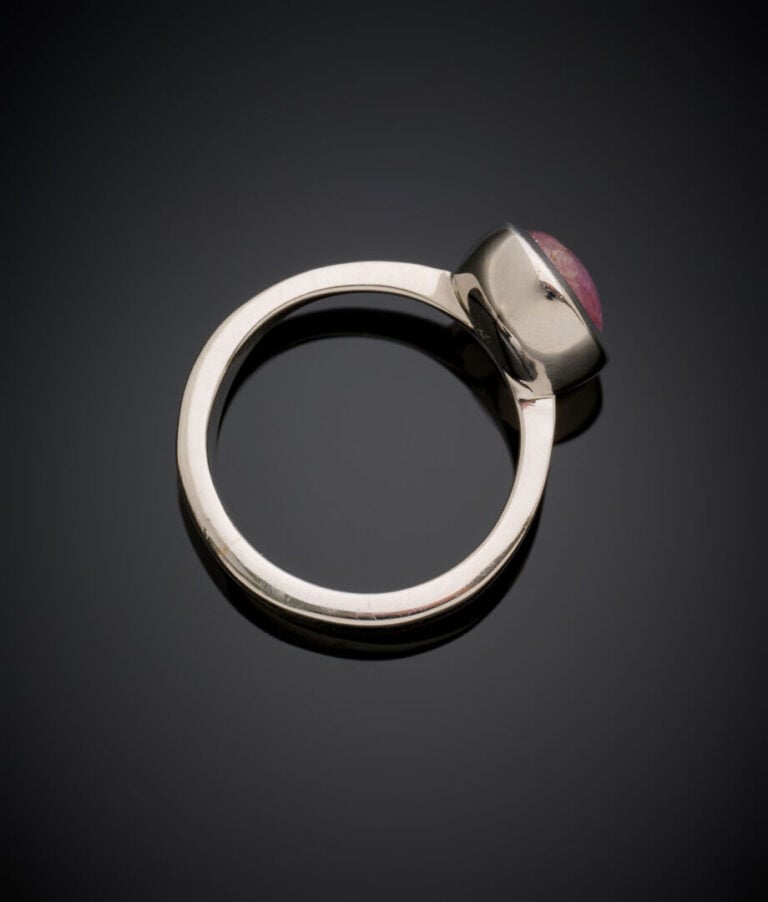 BAGUE en or gris (750‰) serti d'une pierre rouge cabochon étoilée en serti clos…