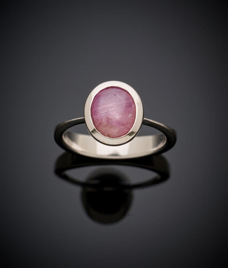 BAGUE en or gris (750‰) serti d'une pierre rouge cabochon étoilée en serti clos…