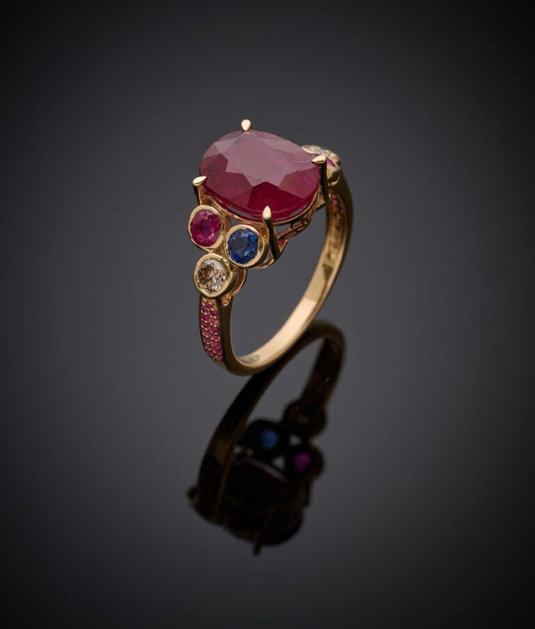 BAGUE en or jaune (375‰) 9 carats, serti d'un rubis de forme coussin épaulé de…