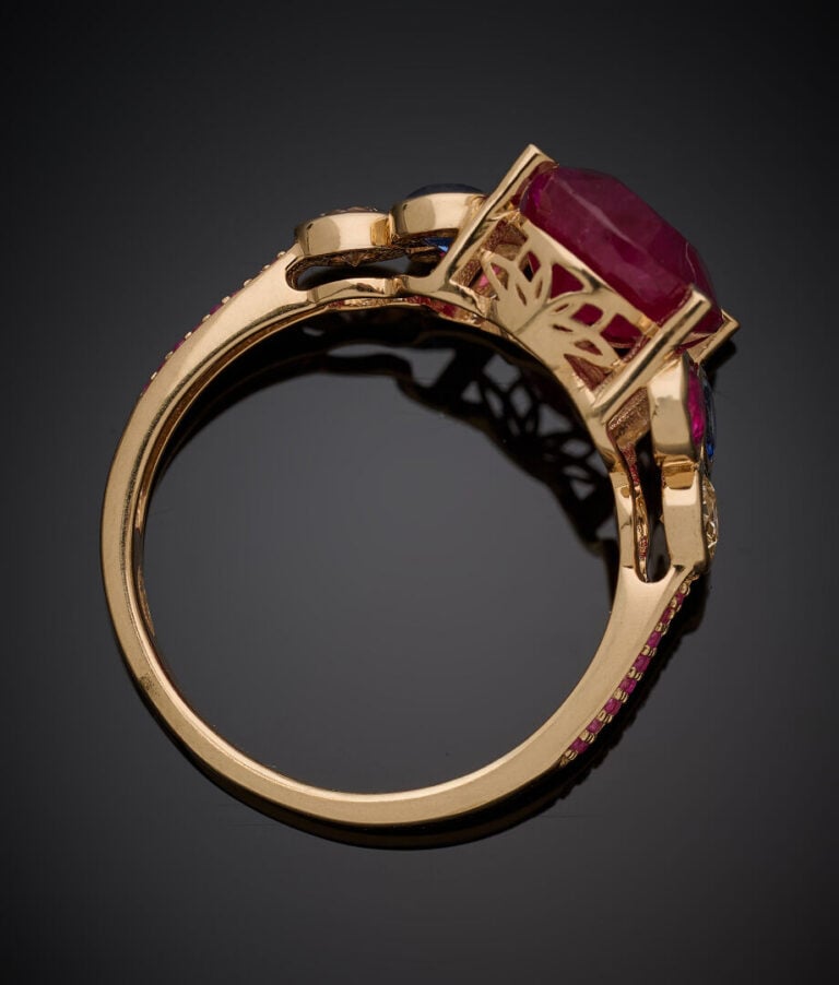 BAGUE en or jaune (375‰) 9 carats, serti d'un rubis de forme coussin épaulé de…