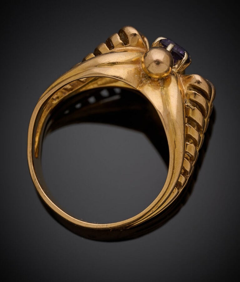 BAGUE en or jaune (750‰) ajouré, serti d'une pierre violette de remplacement. -…