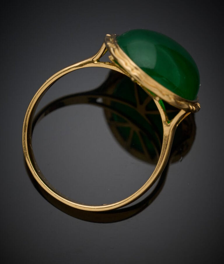 BAGUE en or jaune (750‰) serti d'un jade traité cabochon de forme ovale en sert…