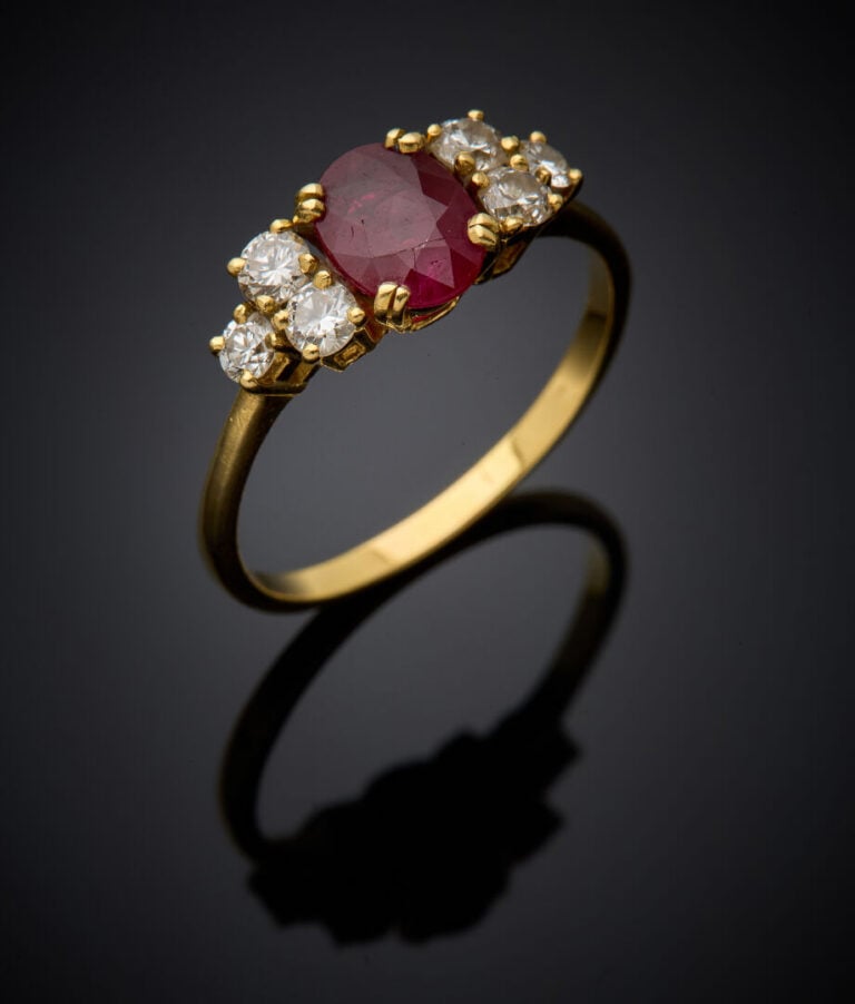 BAGUE en or jaune (750‰) serti d'un rubis ovale, épaulé de trois diamants taill…