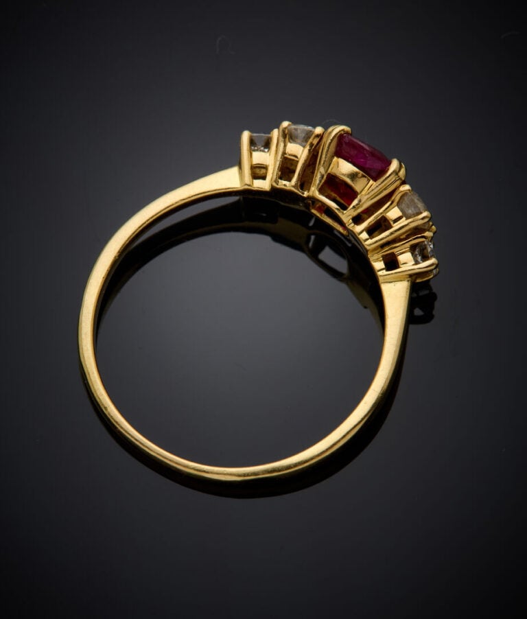 BAGUE en or jaune (750‰) serti d'un rubis ovale, épaulé de trois diamants taill…