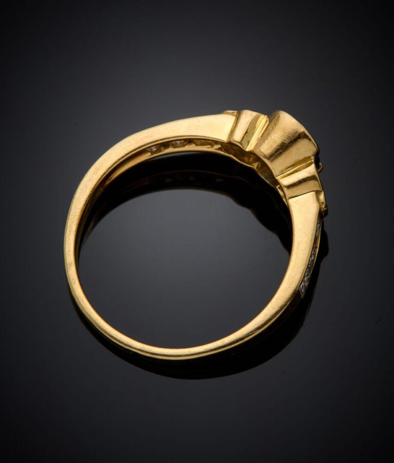 BAGUE en or jaune (750‰) serti d'un saphir ovale (choc) et épaulé de diamants t…