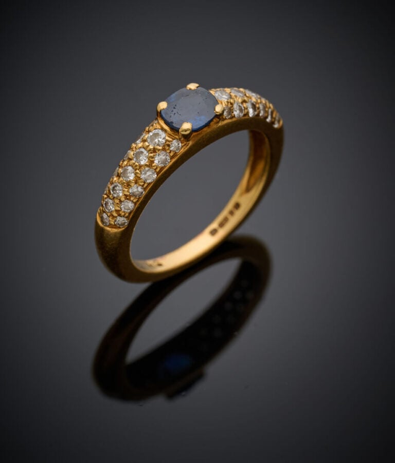BAGUE en or jaune (750‰) serti d'un saphir ovale, épaulé de diamants taille bri…