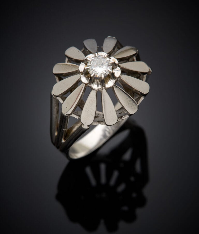 BAGUE "fleur" en or gris (750‰) ajouré, serti d'un diamant demi-taille. Travail…