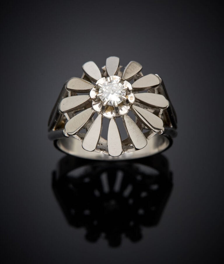 BAGUE "fleur" en or gris (750‰) ajouré, serti d'un diamant demi-taille. Travail…