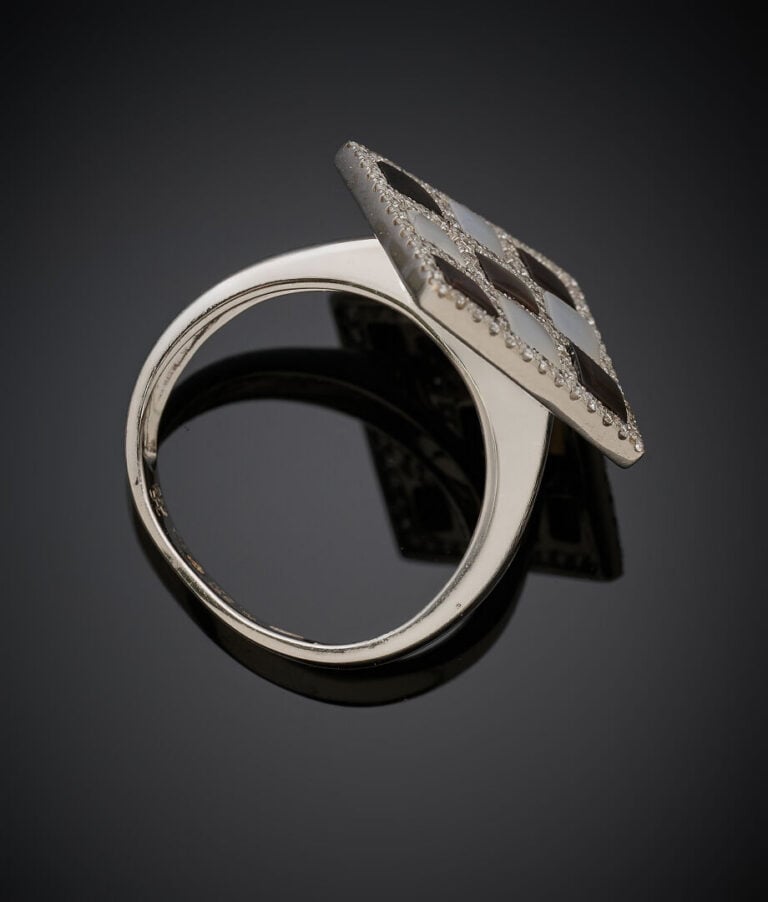 BAGUE losangique en or gris (750‰) orné de nacre blanche et grise alternée de d…