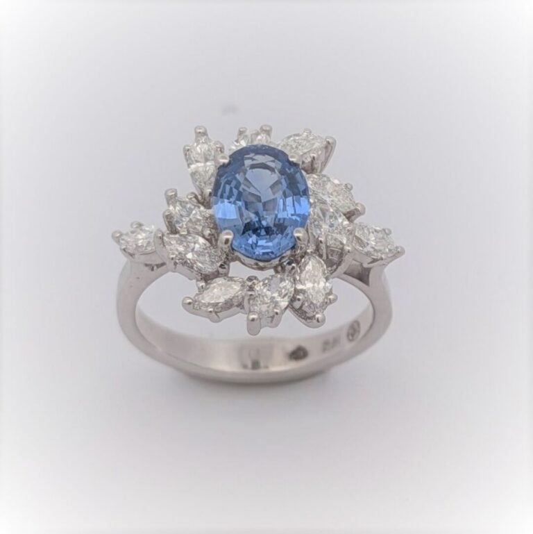 Bague "marguerite" en or blanc (750 ‰) serti d'un saphir de forme ovale entouré…