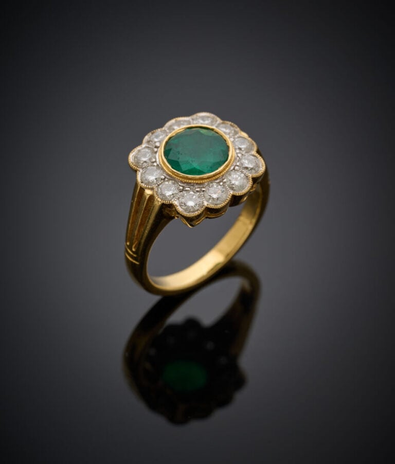 BAGUE "marguerite" en or jaune (750‰) serti d'une émeraude ronde, entourée de d…