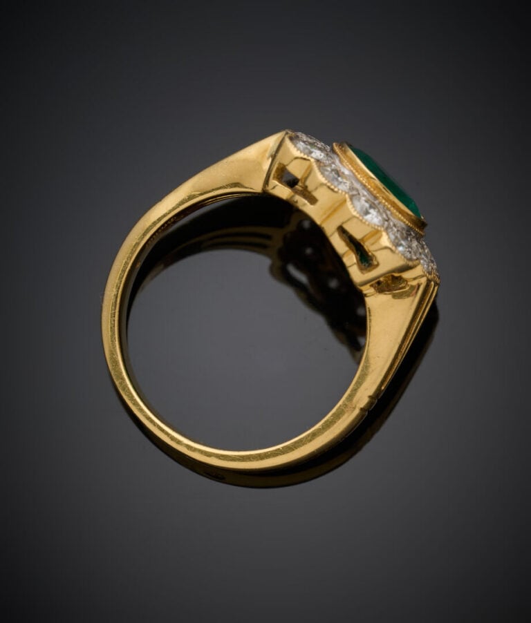 BAGUE "marguerite" en or jaune (750‰) serti d'une émeraude ronde, entourée de d…