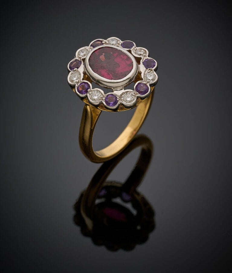 BAGUE "marguerite" en or jaune et or gris (750‰) serti d'un grenat rhodolite de…