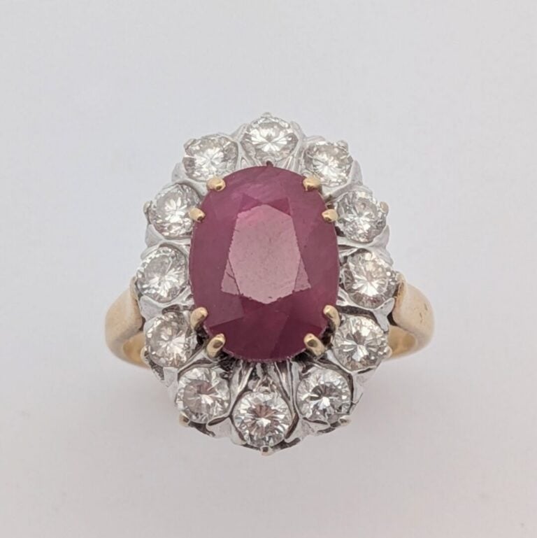 BAGUE "marguerite" en or jaune et or gris (750‰) serti d'un rubis ovale, entour…